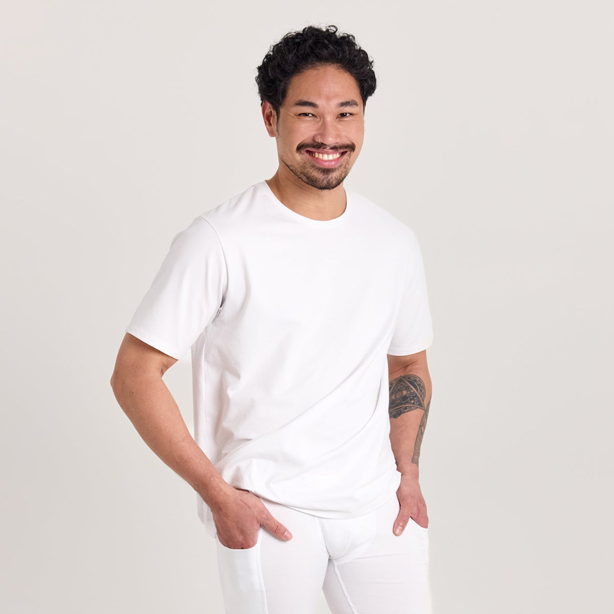 Mies valkoisessa unisex-mallisessa t-paidassa, missä pyöreä pääntie