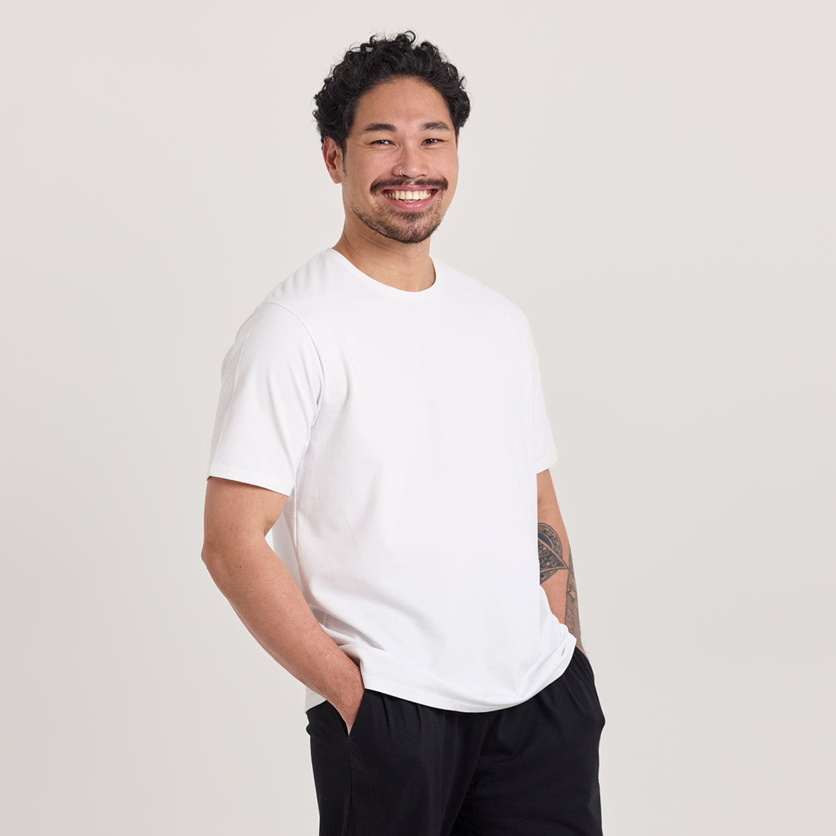 Mies valkoisessa unisex-mallisessa t-paidassa, missä pyöreä pääntie