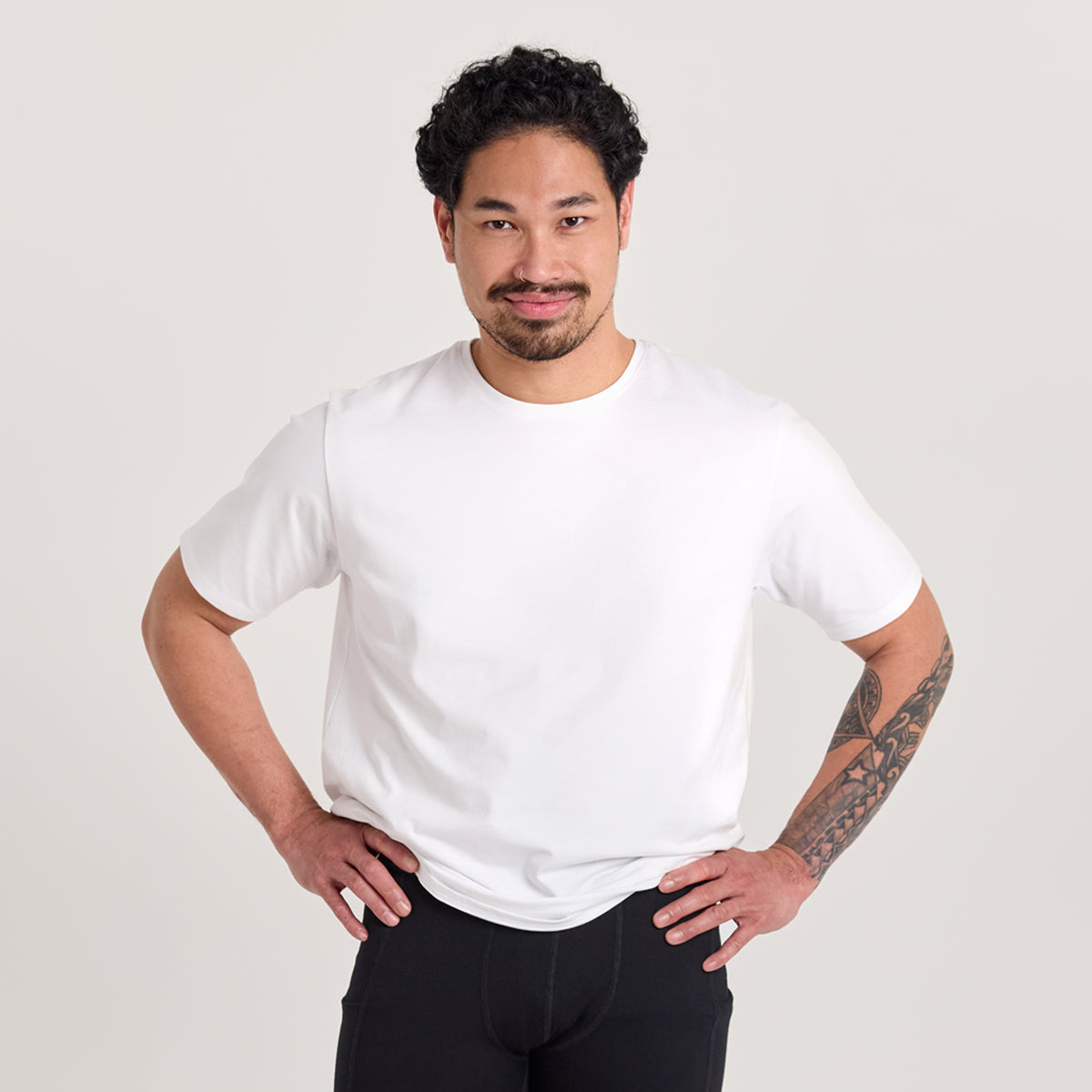Mies valkoisessa unisex-mallisessa t-paidassa, missä pyöreä pääntie
