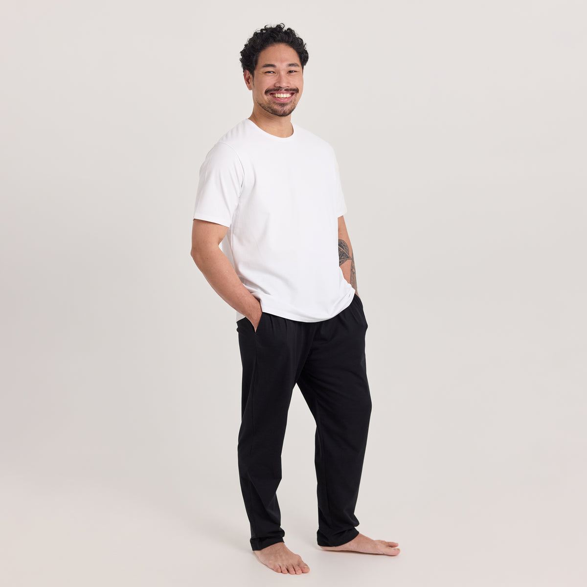 Mies valkoisessa unisex-mallisessa t-paidassa, missä pyöreä pääntie