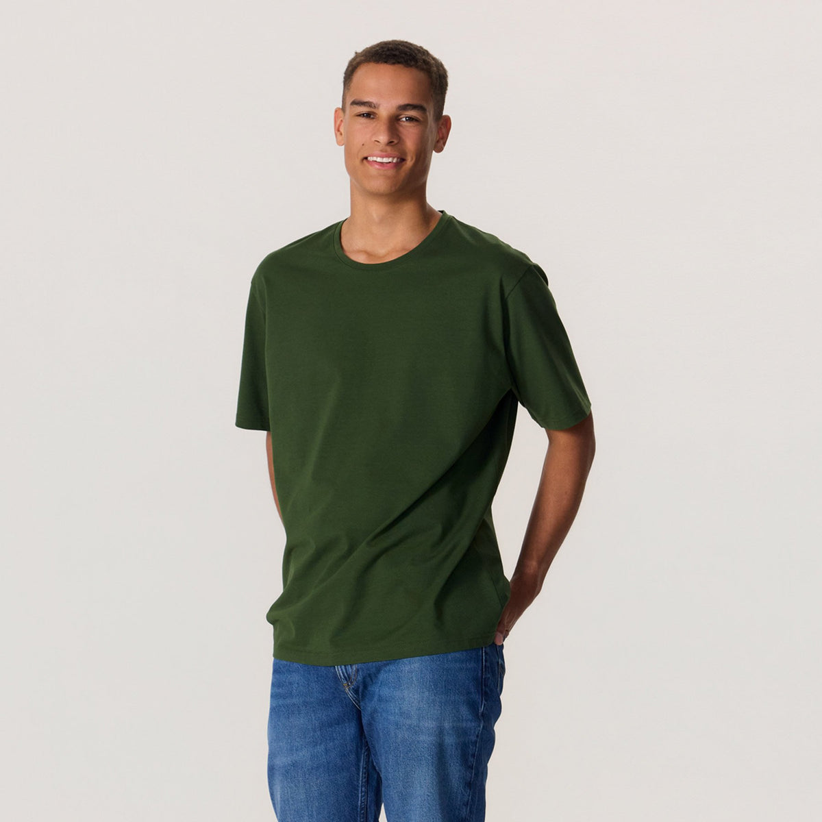 Miesmalli maastonvihreässä unisex-mallisessa t-paidassa, missä pyöreä pääntie