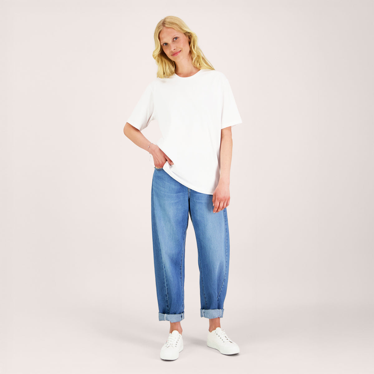 Nuori nainen valkoisessa unisex-mallisessa t-paidassa, jossa pyöreä pääntie